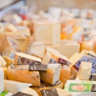 KI generiert: Verschiedene Käsestücke auf einem Markt oder in einem Laden ausgestellt.