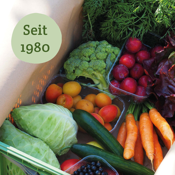 KI generiert: Eine Kiste mit frischem Obst und Gemüse, Text "Seit 1980".