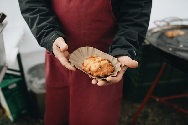 KI-generierte Beschreibung: Eine Person hält ein Stück Kuchen in den Händen.