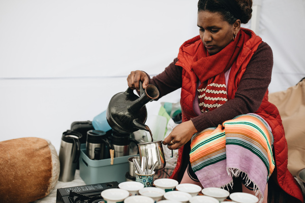 KI-generierte Beschreibung: Ein Mann bereitet Kaffee in einer traditionellen Kaffeerösterei zu.